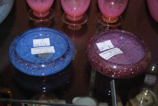 TWO MONART GLASS PIN DISHES, ONE MOTTLED BLUE WITH GOLD COLOURED INCLUSIONS, THE OTHER PURPLE WITH