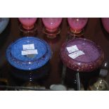 TWO MONART GLASS PIN DISHES, ONE MOTTLED BLUE WITH GOLD COLOURED INCLUSIONS, THE OTHER PURPLE WITH