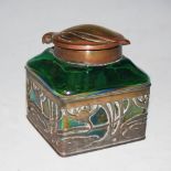 AN ART NOUVEAU IRIDESCENT GREEN GLASS INKWELL WITH PIERCED METAL OVERLAID MOUNT