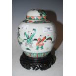 A CHINESE PORCELAIN FAMILLE VERT JAR AND COVER, QING DYNASTY, DECORATED WITH BOYS PLAYING, RAISED ON