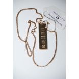 A 9CT GOLD INGOT SUSPENDED FROM YELLOW METAL CHAIN STAMPED '9K', GROSS WEIGHT 20.4 GRAMS.