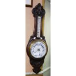 AN EARLY 20TH CENTURY OAK BAROMETER OF BANJO FORM WITH WHITE DIAL WITH BLACK PRINT, THE NECK WITH