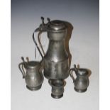 AN ANTIQUE PEWTER TAPPIT HEN, TOGETHER WITH TWO GRADUATED LIDDED TANKARDS AND A MINIATURE TANKARD