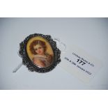 LATE 19TH/ EARLY 20TH CENTURY OVAL PORTRAIT LOCKET DEPICTING YOUNG GIRL WITHIN WHITE METAL