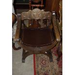 A 20TH CENTURY CONTINENTAL CARVED WALNUT X-SHAPE CHAIR WITH STRETCHED DARK BROWN LEATHER SEAT, THE