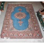 A 20TH CENTURY TURKISH KAYSERI WOOL RUG ON A TEAL BLUE GROUND WITH REPEATING DESIGN IN CREAM, PINK