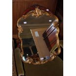 A 20TH CENTURY ROCOCO STYLE WALL MIRROR, THE C-SCROLL COMPOSITE GILT PAINTED FRAME WITH PLAIN MIRROR