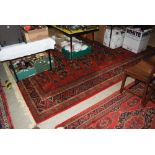 A LARGE 20TH CENTURY ROYAL KESHAN SOUMAC CARPET WITH LABEL TO BACK, IN DARK RED GROUND WITH