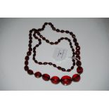 A FACETED FAUX AMBER GRADUATED BEAD NECKLACE.