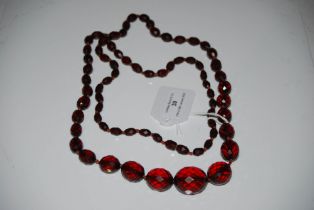 A FACETED FAUX AMBER GRADUATED BEAD NECKLACE.