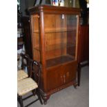 AN EARLY 20TH CENTURY CARVED OAK GLAZED DISPLAY CABINET, THE SLIDING GLASS DOORS REVEALING TWO GLASS