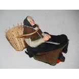 A MODEL DOLL DEPICTING A PORTOBELLO FISH WIFE WITH WOVEN WOOL SHAWL AND WICKER CREEL