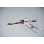 YELLOW METAL AND AMETHYST SET BAR BROOCH, STAMPED '15CT', GROSS WEIGHT 3.7 GRAMS.