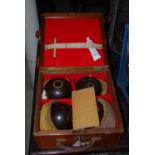 A VINTAGE SET OF FOUR BOWLING BALLS IN MAHOGANY BOX WITH LEATHER CARRY HANDLE