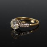 A mid 20th century yellow and white metal single stone diamond ring with diamond set shoulders,