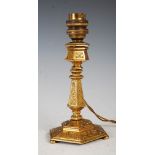 A late 19th century gilt bronze candlestick, probably French, of hexagonal tapering form with a