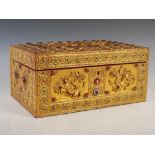 An Indian gilded wood and richly decorated casket, the hinged cover carved in relief with kneeling
