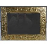 An early 20th century Glasgow School Arts & Crafts brass mirror, circa 1900, the frame embossed with