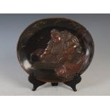 A Japanese late Meiji period bronze circular dish-shaped plaque, decorated in patinated and gilt