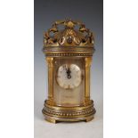 A late 19th century gilt and silvered bronze repeating carriage clock, the case of round