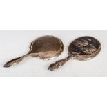 Two late 19th / early 20th century silver hand mirrors, the first of oval form, the back and
