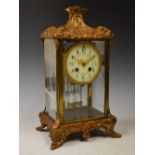 A late 19th/ early 20th century gilt metal mantle clock, the circular dial with Arabic numerals