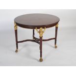 An Empire style mahogany and giltwood table, 20th century, the round top of plain form with a dentil