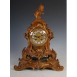 A late 19th century French gilt bronze mantel clock, the case of Rococo style, surmounted by a