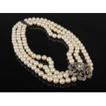 A late 19th/ early 20th century triple strand cultured pearl necklet with white and yellow metal