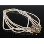 A 20th century five strand cultured pearl necklet with an 18ct yellow and white gold diamond set