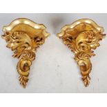 A pair of 20th century carved giltwood wall brackets, the serpentine tops supported by scrolling