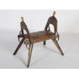 An early 20th century Middle Eastern brass inlaid saddle / camel stool, formed of two arched sides