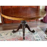 A 19th century Padouk snap top supper table, the hinged circular top resting on a tapered