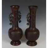 A pair of Chinese bronze Gu vases, with long necks with twin handles and ovoid bodies on round
