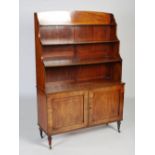 A Regency mahogany waterfall bookcase, with ebony string inlay, fitted three graduated shelves above