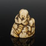 A Japanese carved ivory netsuke, possibly Edo period, depicting two laughing sages, unsigned, 4cm