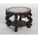 An early 20th century small Chinese carved darkwood stand, the lobed round top inset with red veined