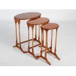 An early 20th century painted satinwood nest of three occasional tables, each oval top of plain form