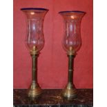 A pair of late 19th century/ early 20th century brass hurricane lamps with clear and blue glass