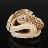 A Japanese carved ivory netsuke, probably Meiji Period, depicting two carp in swirling water, two