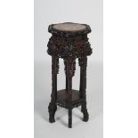 A late 19th / early 20th century Chinese carved darkwood jardiniere stand, the lobed hexagonal top