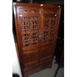 A CHINESE NARROW CABINET, 20TH CENTURY, WITH TWO PIERCED AND PANEL CUPBOARD DOORS OVER AN OPEN
