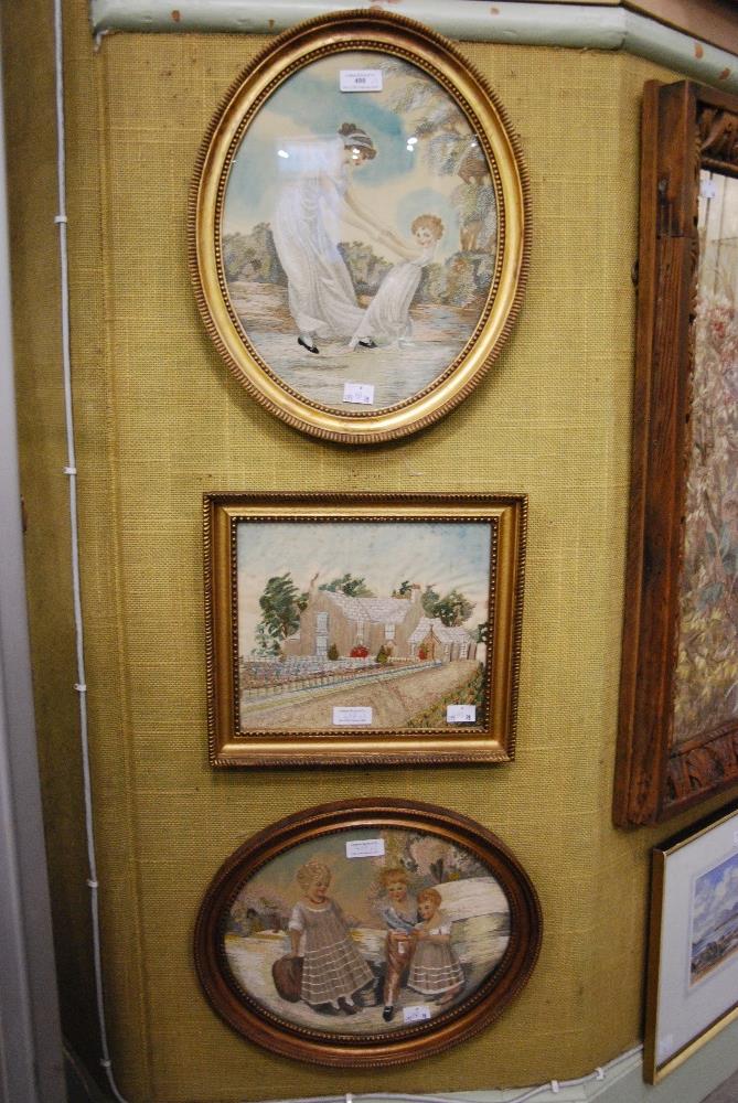 A GROUP OF THREE EARLY 20TH CENTURY FRAMED EMBRIODERED SILK PANELS, INCLUDING AN OVAL SCENE OF A