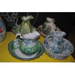FOUR ASSORTED VICTORIAN AND LATER GREEN TRANSFER PRINTED POTTERY EWER AND BASIN SETS.