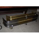 PIERCED BRASS FENDER, TOGETHER WITH ANOTHER SILVERED AND BRASS FENDER ON THREE SHAPED FEET.