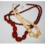 GRADUATED RED AMBER TYPE BEAD NECKLACE, 86.3 GRAMS, TOGETHER WITH ANOTHER GRADUATED BEAD NECKLACE.