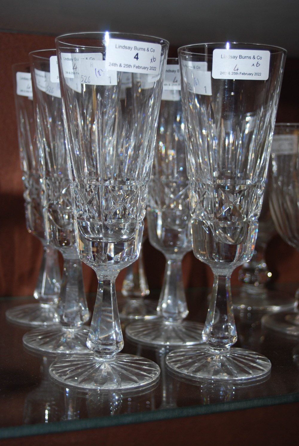 SET OF SIX CUT GLASS CHAMPAGNE FLUTES.