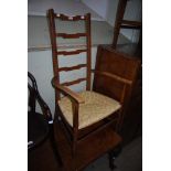 EARLY 20TH CENTURY ARTS AND CRAFTS STYLE BEECH WOOD LADDER-BACK ARMCHAIR WITH WOVEN RAFFIA SEAT.