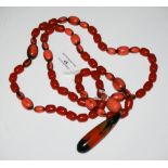 VINTAGE RED AMBER TYPE AND FAUX CORAL NECKLACE SUSPENDING OVAL-SHAPED PENDANT WITH SCREW CAP.