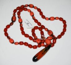VINTAGE RED AMBER TYPE AND FAUX CORAL NECKLACE SUSPENDING OVAL-SHAPED PENDANT WITH SCREW CAP.